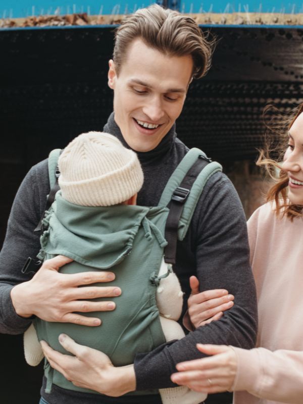 Padre portando alegremente a su bebé en la mochila E-Carrier Diamond Green de Quokkababy